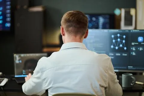 Man Analyzing Cybersecurity Data on Multiple Computer Screens Stock Photos