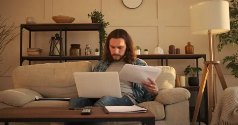 Man analyzing document and using laptop at home Video stock 135847446