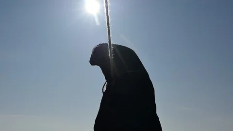 Man in ancient black hoodie pulling rope front view silhouette Stock Footage 103468492