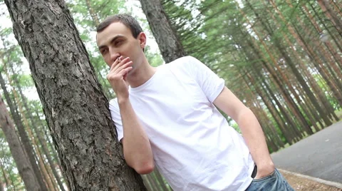 Man with ancigarette at the forest. Man stands and smokes cigarettes and thinks Stock Footage 64909871