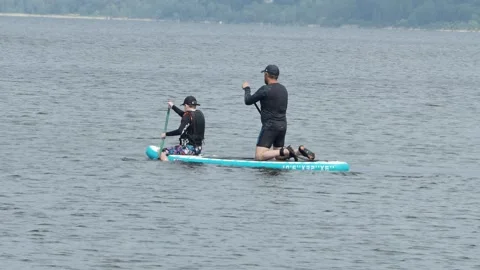 A man and a boy are sailing together on the same sub on the river. Video stock 247008089
