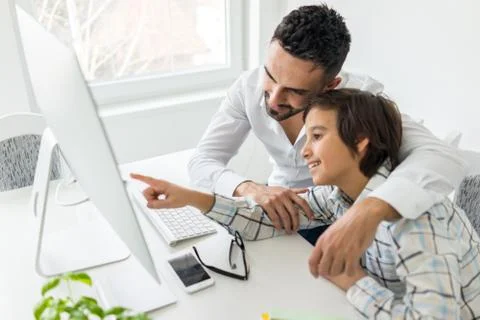 Man and boy on computer Foto stock