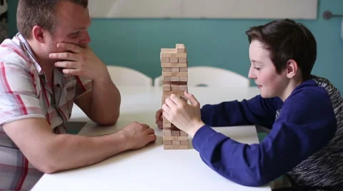 Man and Boy Playing in Board Game at the Table Stock Footage 58240972