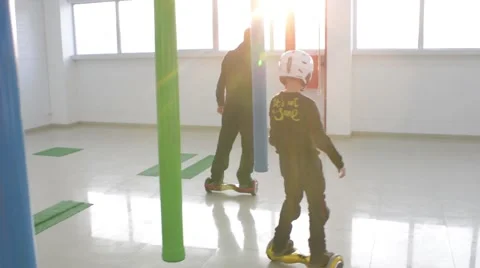 Man and Boy ride balancing Segway motorized scooter io hawk Stock Footage 59539985