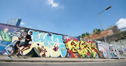 Man and Boy running through Urban Enviroment. Vídeo Stock 67638784