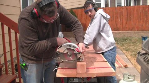 Man and boy sawing from end Stock Footage 22823391