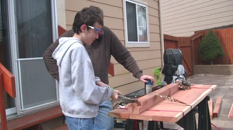 Man and boy sawing Stock Footage 22753015