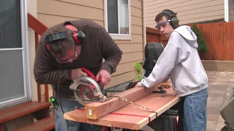 Man and boy sawing Stock Footage 22753215