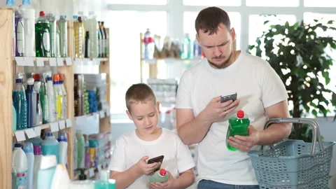 Man and boy scanning qr code for dishwashing detergent Stock Footage 315025575