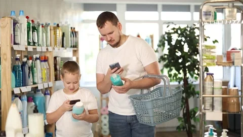 Man and boy scanning qr code for shampoo or shower gel Stock Footage 326314082