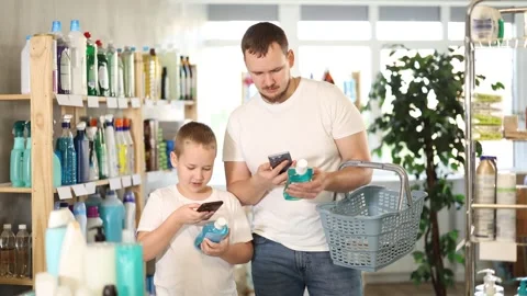 Man and boy scanning qr code for mouthwash Stock Footage 332636734