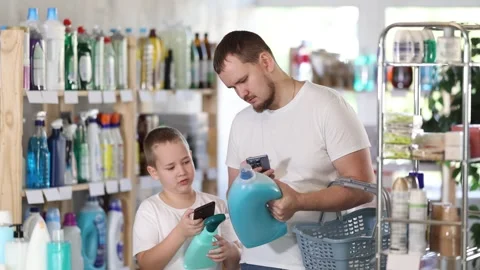 Man and boy scanning qr code for detergent Stock Footage 341426965