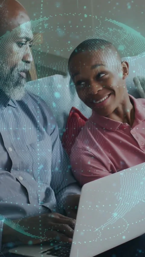 Man and boy sitting on couch, man typing laptop sparking teal dotted tech Stock Footage 331759683