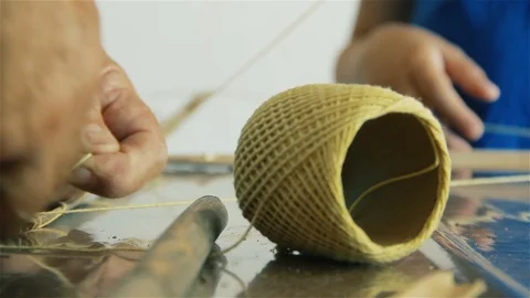 Man and Child making Kite with String Ball and Wood Sticks at Home. Close-Up. Stock Footage 93882093
