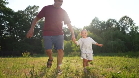 Man and child running through field. Father walking his son in the grass Video stock 316249133