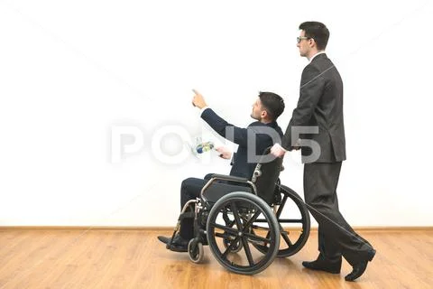 The man and a disabled with papers gesturing on the white wall background Stock Photos