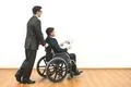 The man and a disabled with papers on the white wall background Photo