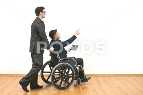 The man and a disabled with a tablet gesturing on the white wall background Stock Photos