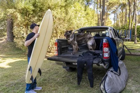 Man and his dog getting ready for a surf trip Stock Photos