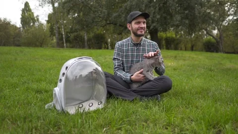 Man and his gray cat take a relaxing break in a city park. The cat arrived in a Stock Footage 337323266