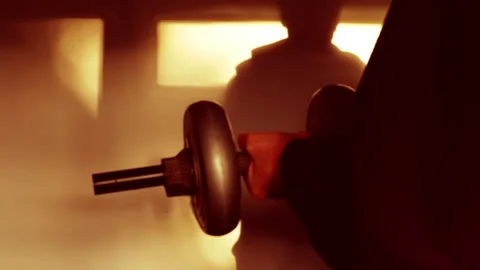 A man and his shadow on a room wall using dumbbell hand weights. Vídeos de archivo 296589358