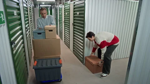 Man and His Son Loading Boxes on Cart and Leaving Storage Facility Stock Footage 327786206