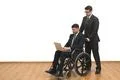 The man and an invalid work with a laptop on the white wall background Photo