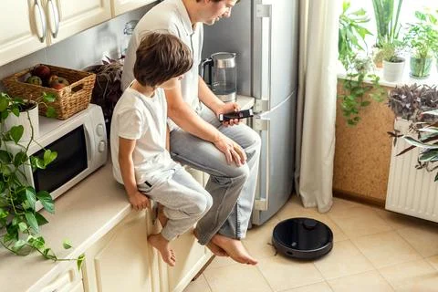 Man and Kid Operating Robotic Vacuum Cleaner Stock Photos