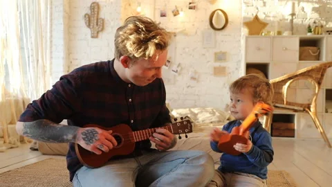 Man and kid playing ukulele Stock Footage 88429205