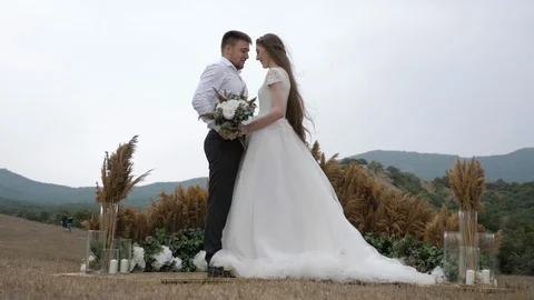 Man and lady stand on brown meadow at wedding decorations Stock Footage 122816396
