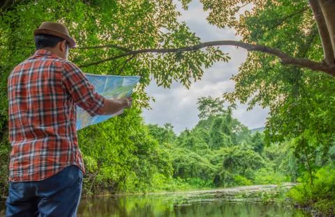 Man and map, path finding in forest and river area, vacation travel idea 스톡 사진