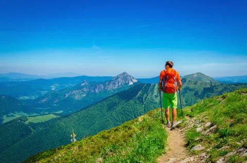 Man and orange backpack on mountain trail Slovakia Stock Photos