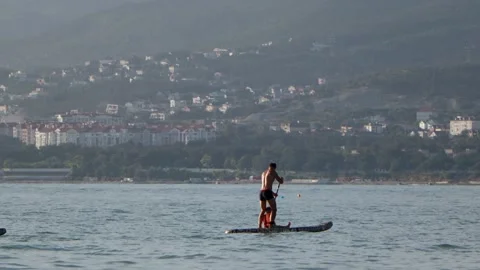 Man and son on sup board in the sea Stock Footage 157087961