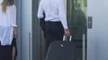 Man and woman approaching elevator doors, entering lift, male carrying suitcase HD Footage
