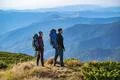 The man and a woman with backpacks standing on the mountain Photo