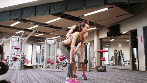 Man and woman with barbell flexing muscles in gym Stock Footage