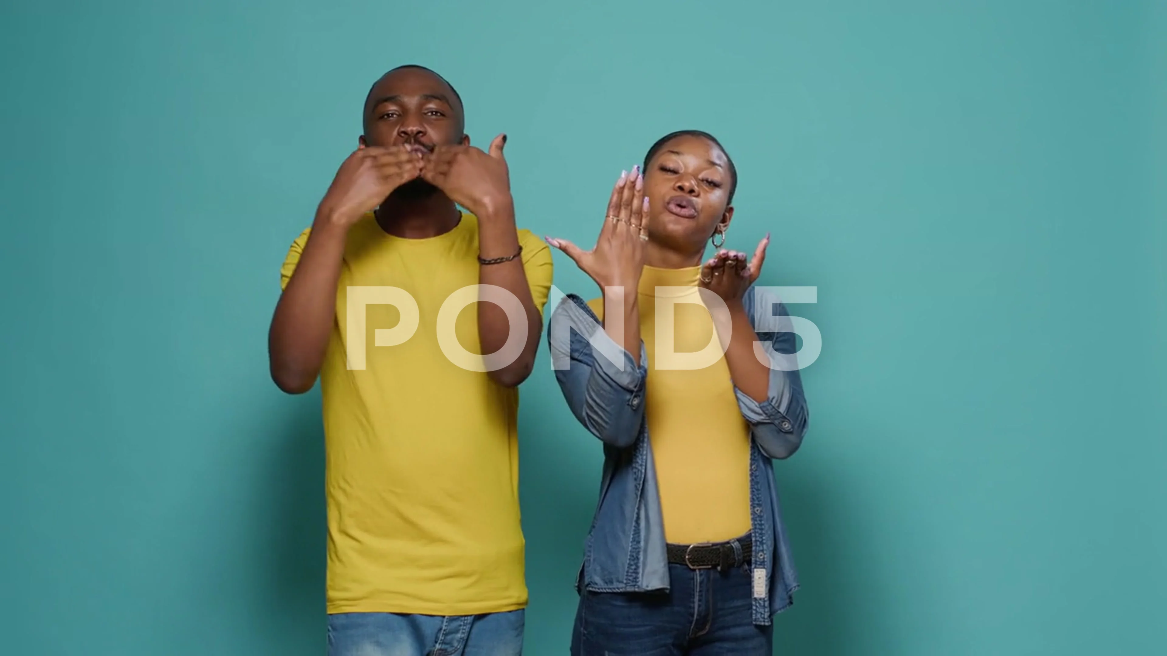 Man and woman blowing air kisses with hands and lips on studio camera