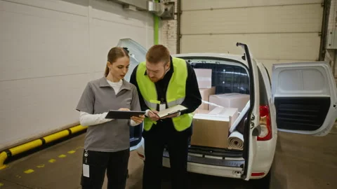 Man and Woman Checking Delivery List on Tablet by Open Van Stock Footage 340282904