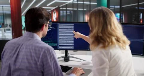 Man And Woman Coding Web Software With Instructor Guidance Remotely Foto stock
