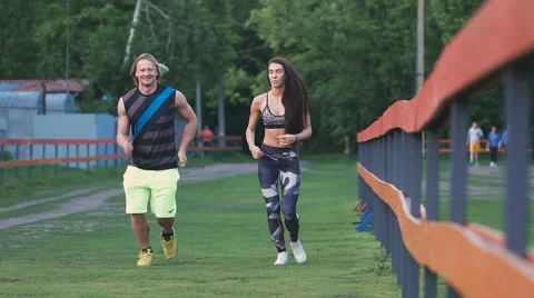 Man and woman commit a jog. They are young and attractive, communicate with each Video stock 63533341
