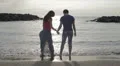 a man and a woman dancing and hugging by the sea at sunset HD Footage