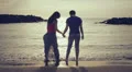 a man and a woman dancing and hugging by the sea at sunset HD Footage