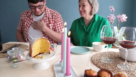 Man and woman eating Easter cake and drinking coffee on dinner table Stock Footage 303636618
