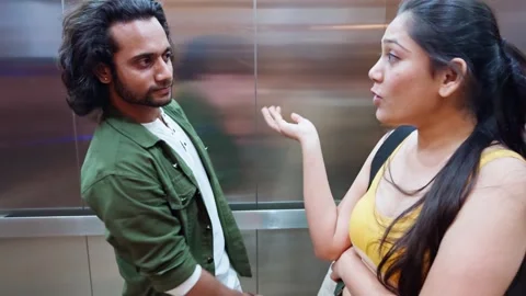 Man and woman in an elevator talking playful Stock Footage 276776799