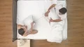 The man and woman fight with a pillow in the bed. view from above 4k or 4k+ Resolution