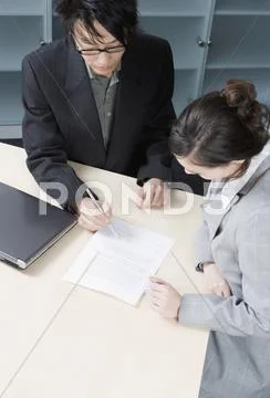 A Man And A Woman Having A Discussion In A Conference Room
