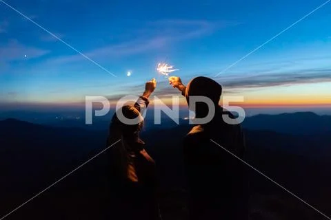 The man and a woman hold firework sticks. evening night time Stock Photos