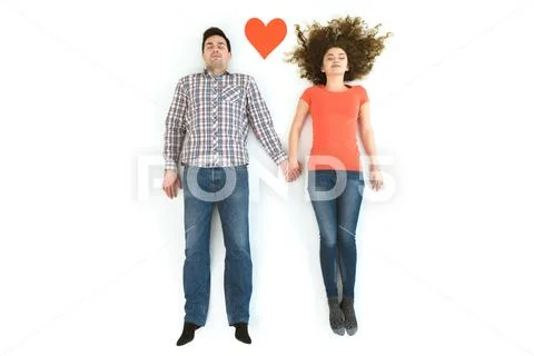 The man and woman lay near the heart sign. View from above Stock Photos