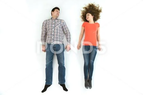 The man and woman lay on the white floor. View from above Stock Photos