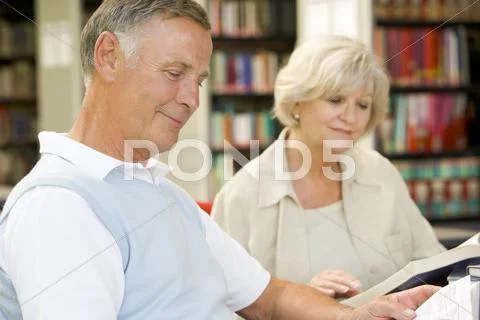 Man and woman in library reading (selective focus) Stock Photos